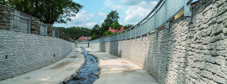 A concrete walkway with a fence and a stream

Description automatically generated with medium confidence