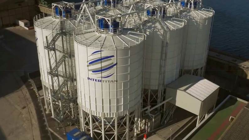 A large white silos with blue and white logos

Description automatically generated